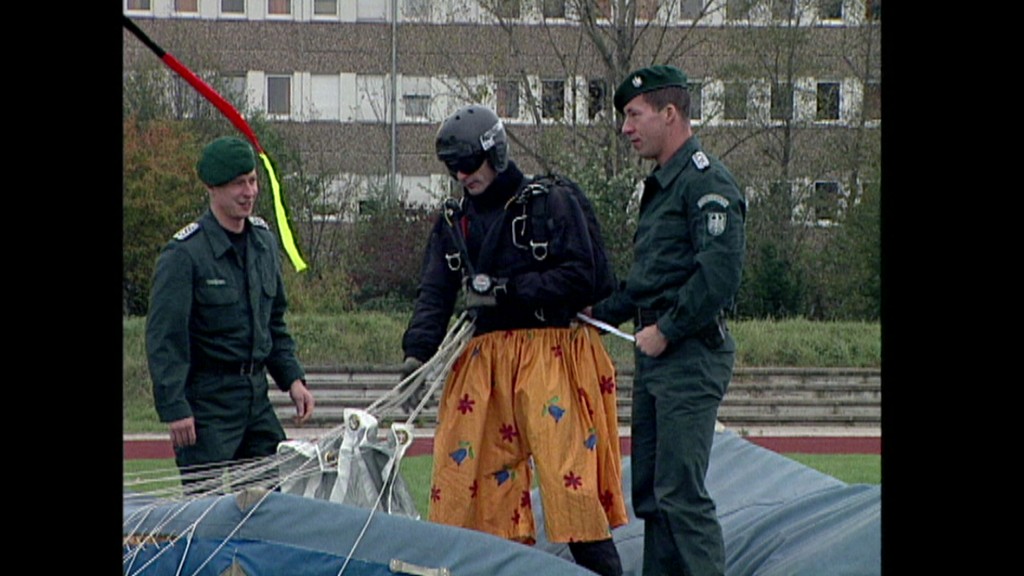 Foto: Zwei Soldaten helfen einem Fallschirmspringer