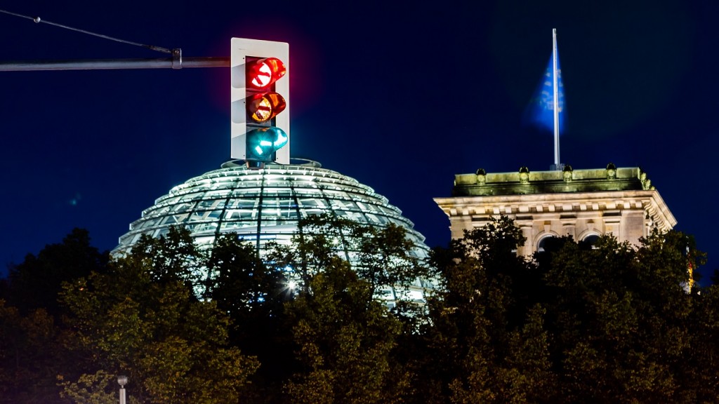 Eine Ampel vor dem Reichstagsgebäude leuchtet in einer Langzeitbelichtung in allen drei Phasen (Foto: picture alliance/dpa | Christoph Soeder)