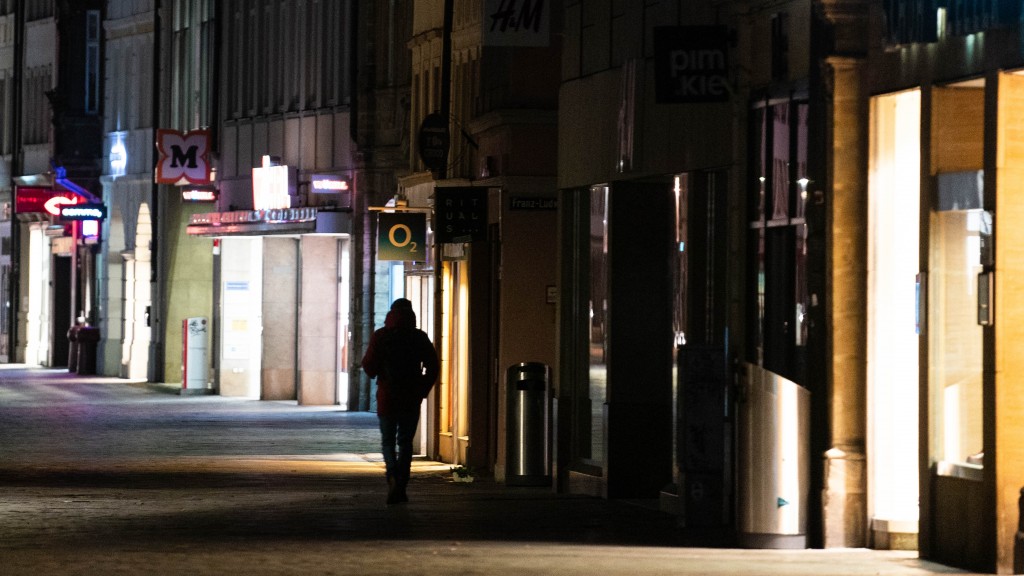 Beleuchtete Geschäfte in einer Einkaufsstraße bei Nacht