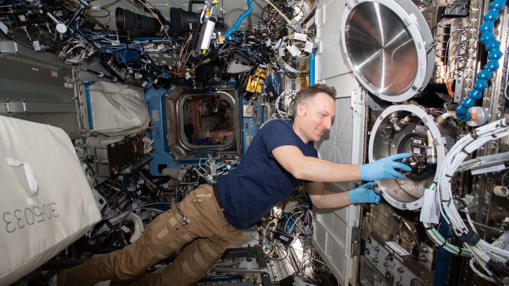 Matthias Maurer gleitet während den Arbeiten an einem Experiment schwerelos durch die ISS