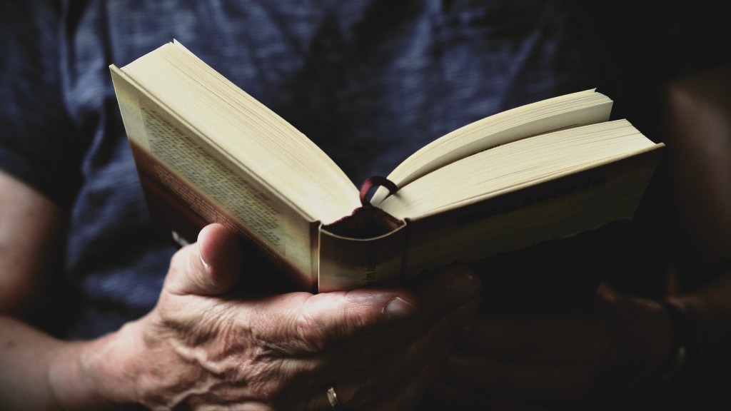 Eine ältere Frau hält ein Buch aufgeschlagen in der Hand