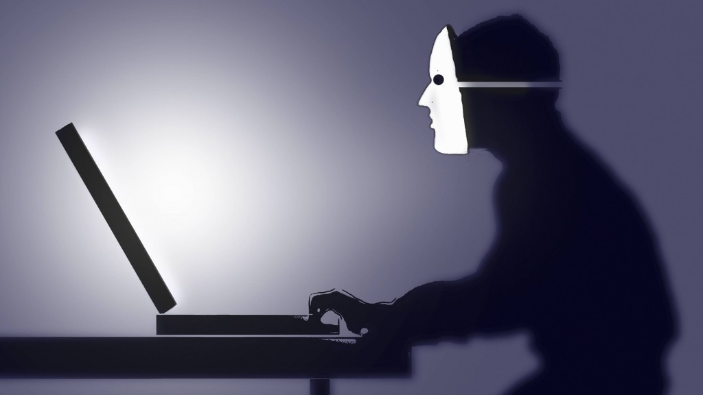 Ein Mann mit Maske vor einem Computer