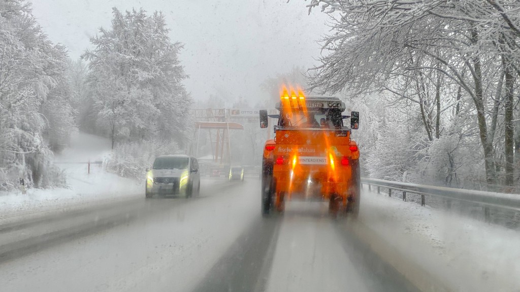 Foto: Ein Räumfahrzeug fährt auf einer verschneiten Landstraße