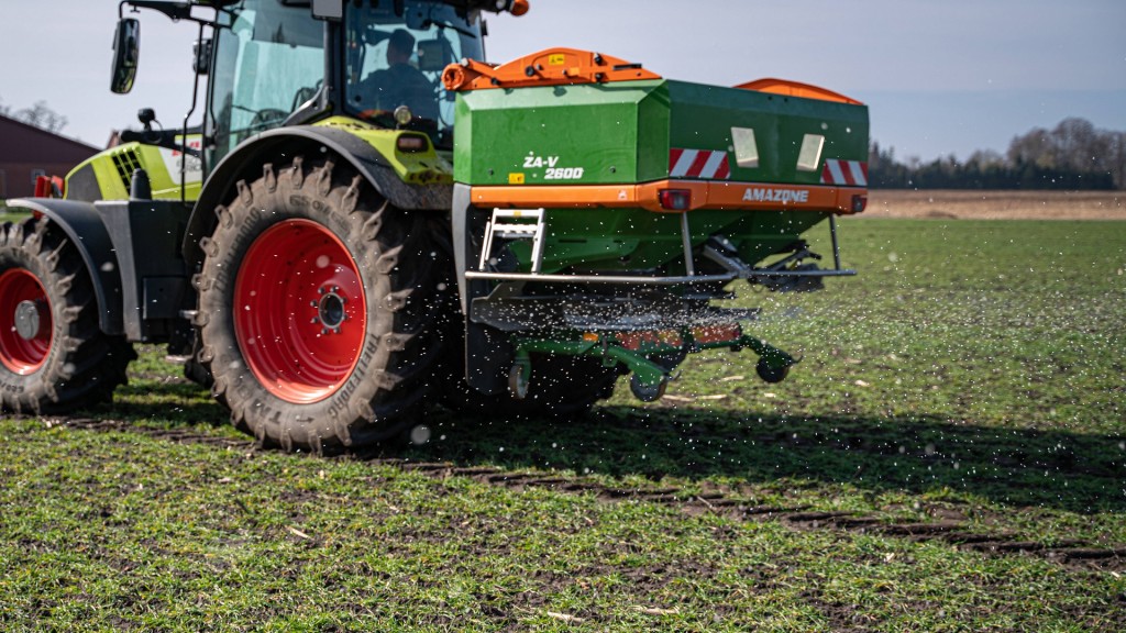 Ein Bauer fährt Mineraldünger auf einem Feld aus.