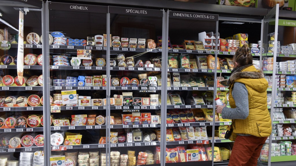 Eine Frau steht an einem Kühlregal in einem französischen Supermarkt