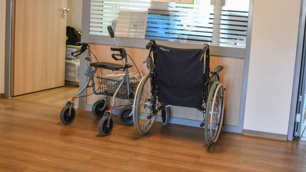 Gehilfe und Rollstuhl stehen vor dem Schwesternzimmwer in einem Pflegeheim