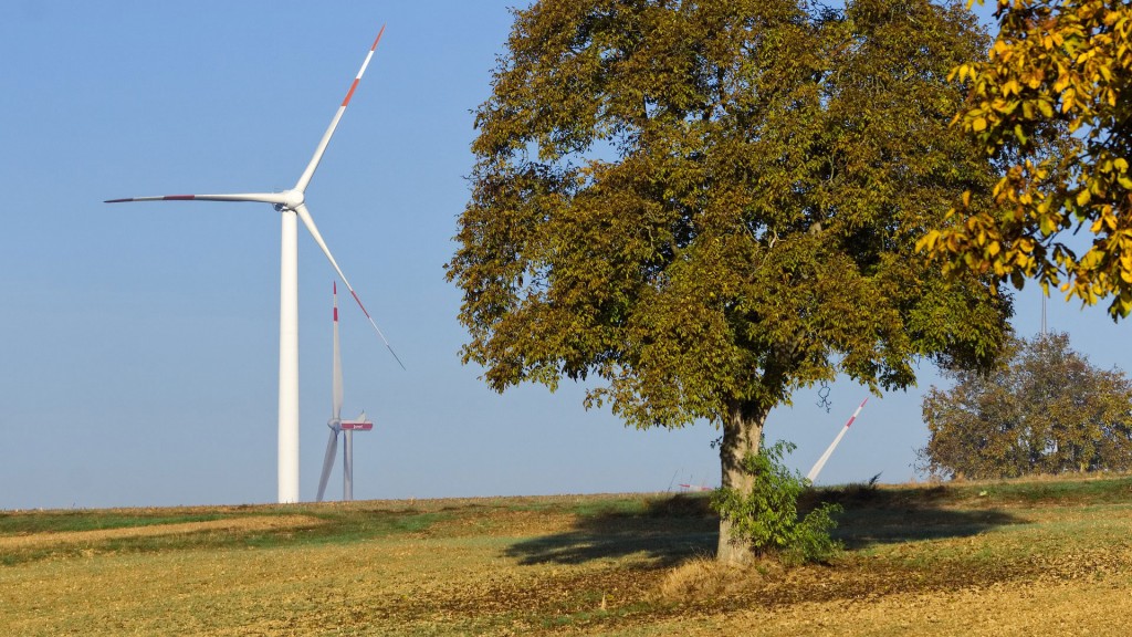 Windräder hinter einer Baumgruppe