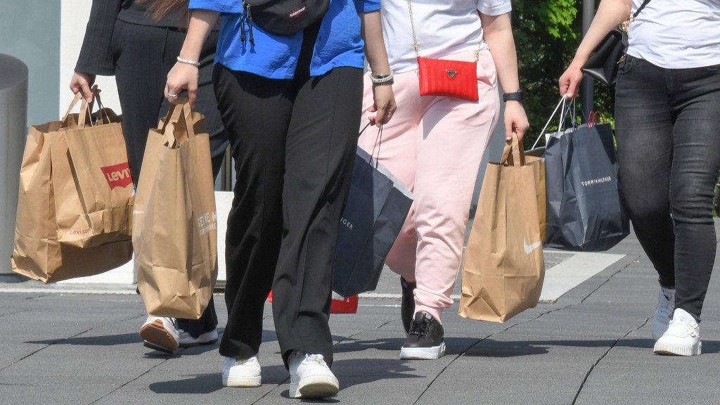 Eine Gruppe von Frauen bepackt mit Einkaufstüten in einer Fußgängerzone.