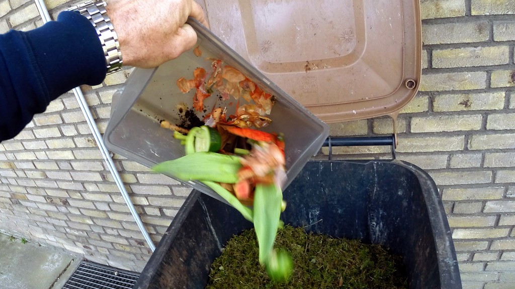 Ein Mann leert Küchenabfälle in eine Biotonne