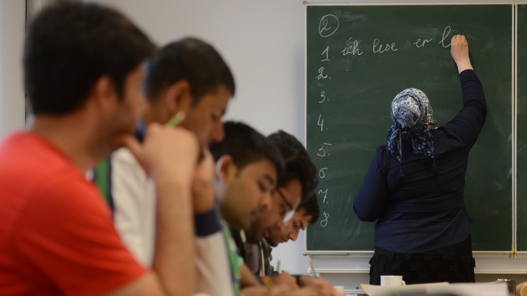 Eine Teilnehmerin eines Sprachkurses schreibt Vokabeln an die Tafel