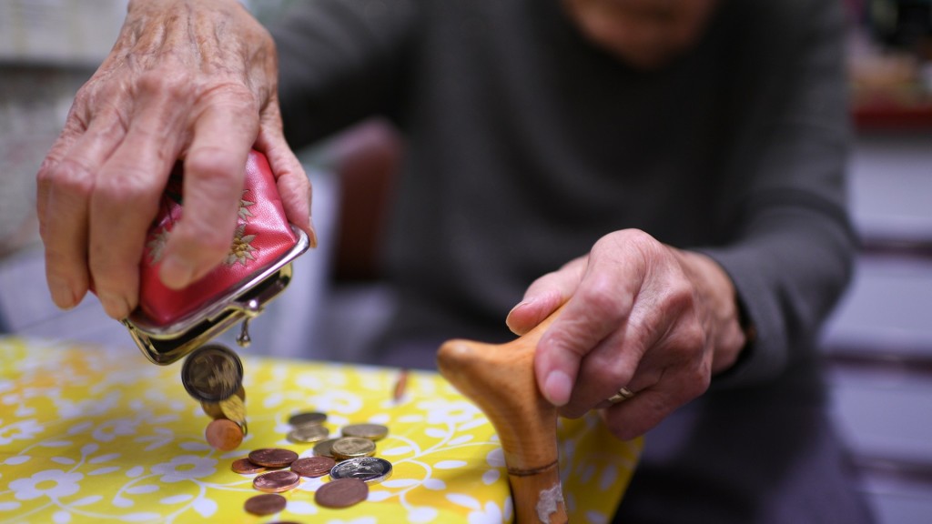Foto: Eine Rentnerin schüttet den Inhalt ihres Geldbeutel auf den Küchentisch