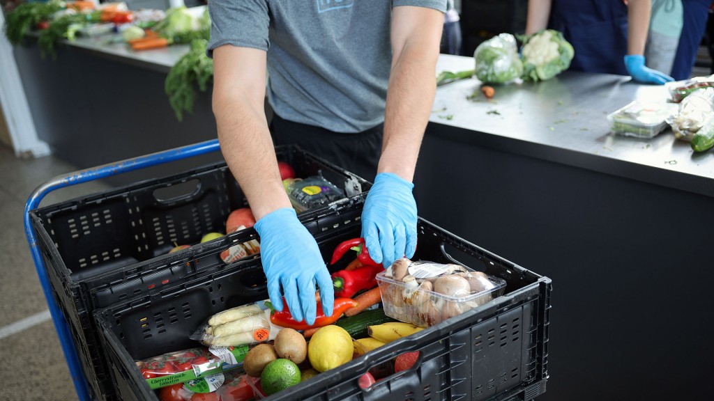 Foto: Ein ehrenamtlicher Helfer entpackt und sortiert Lebensmittel