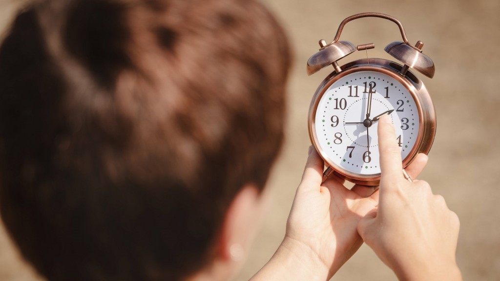 Ein junger Mensch stellt eine Uhr um