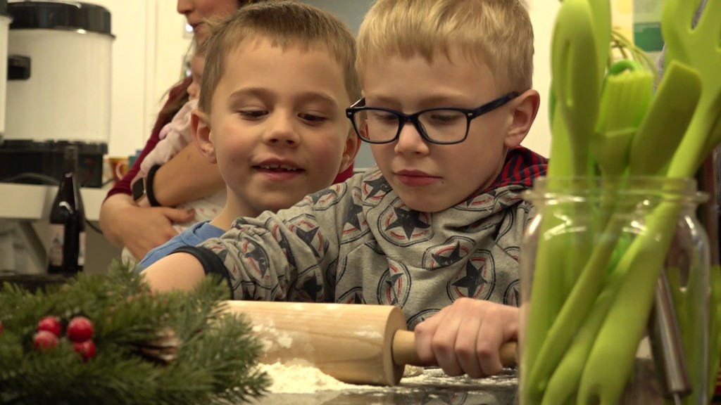 Zwei Kinder rollen einen Keksteig aus