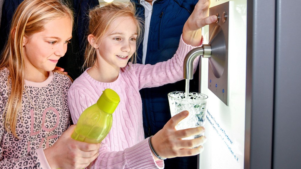 Schülerinnen bedienen den Trinkwasserspender in einer Schule