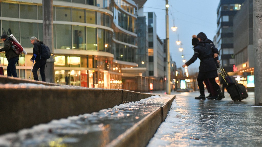 Fußgänger mit Koffern und Taschen auf vereistem Weg zum Saarbrücker Hauptbahnhof