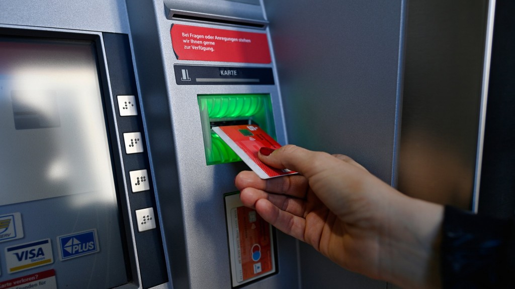 Frau führt ec-Karte am Geldautomat einer Sparkasse ein