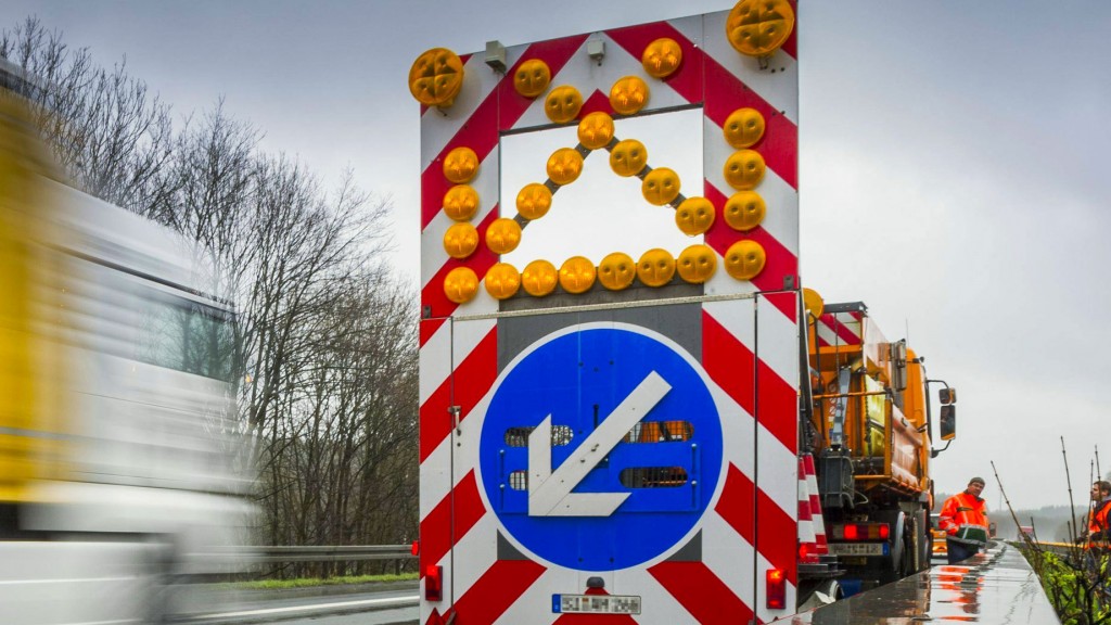 Ein Schild vor einer Autobahnbaustelle weist auf erforderlichen Spurwechsel hin