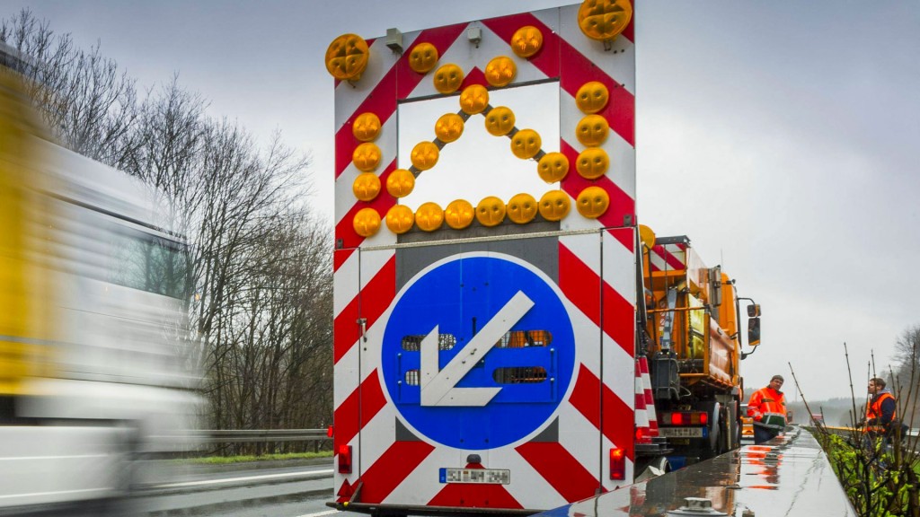 Ein Schild vor einer Autobahnbaustelle weist auf erforderlichen Spurwechsel hin