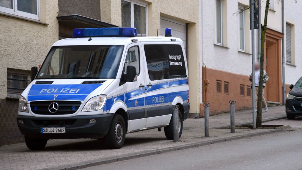 Ein Fahzeug der Polizei mit der Aufschrift „Tatortgruppe Vermessung“ steht vor einem Wohngebäude in der Metzer Straße, Saarbrücken
