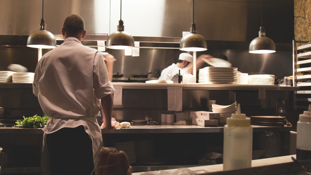 Menschen stehen in einer Restaurantküche und kochen.