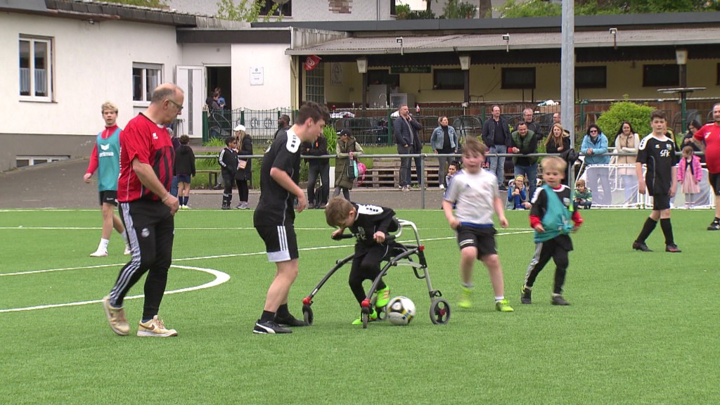 Foto: Ein Junge mit Rollator dribbelt gekonnt mit dem Ball.