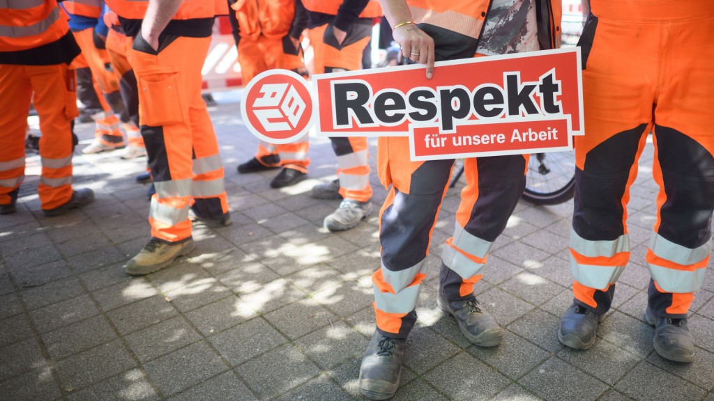 Streikende Bauarbeiter halten ein Schild mit der Aufschrift 