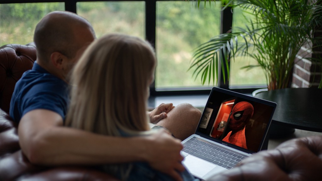 Ein paar sitzt auf dem Sofa mit Laptop und streamt einen Film