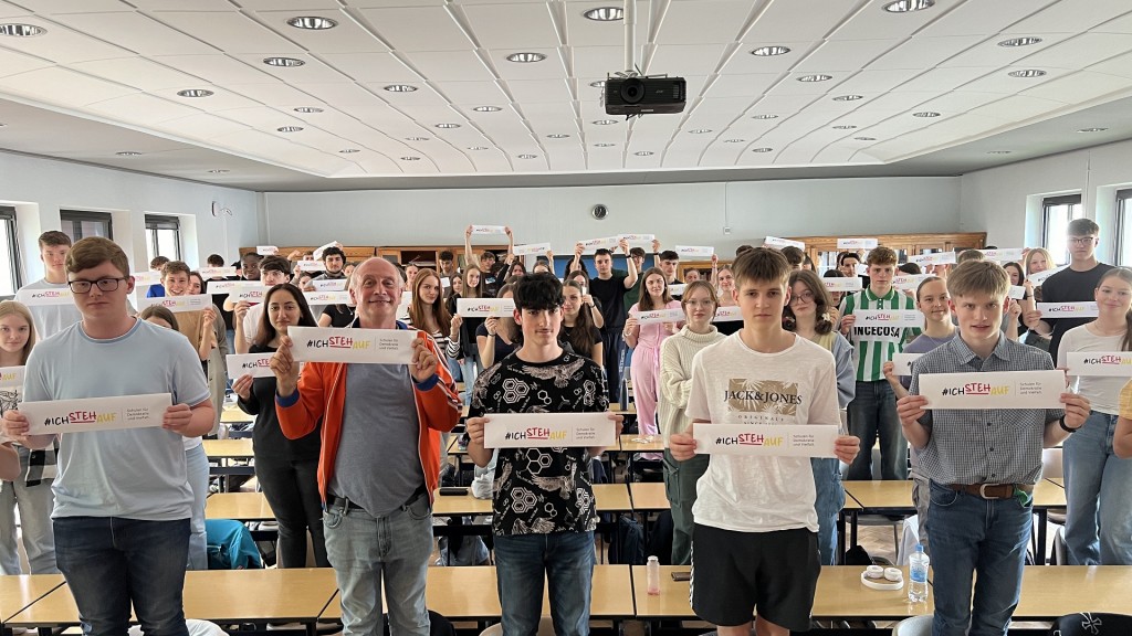 Kabarettist Alfons steht gemeinsam mit Schülern auf Stühlen - für die Aktion #ichstehauf