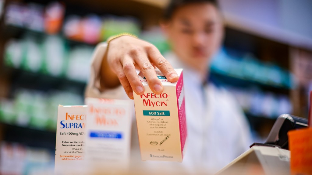 Ein Mitarbeiter einer Apotheke greift nach einer Packung Antibiotikasaft für Kinder. 