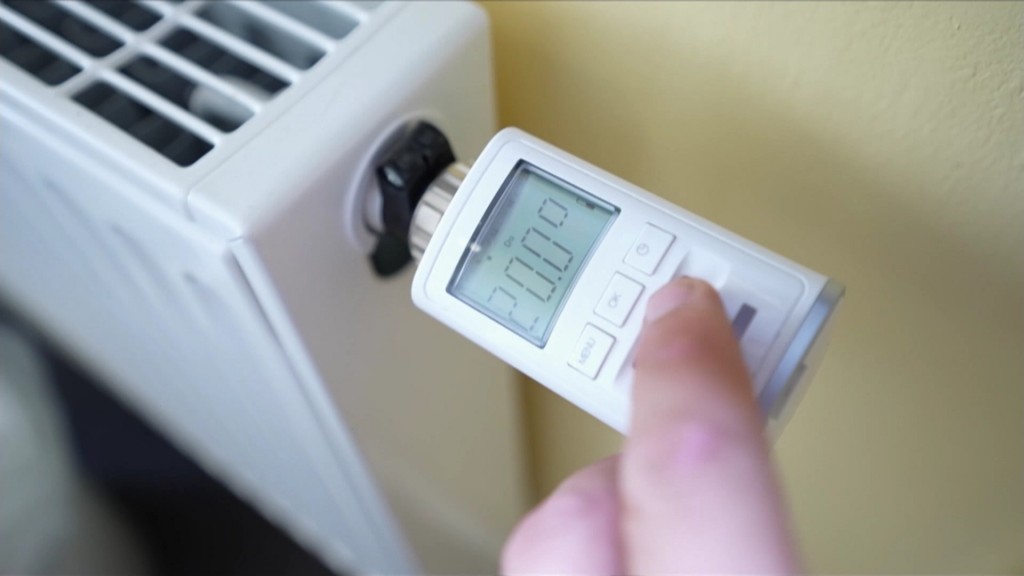 Person reguliert Temperatur des Heizkörpers