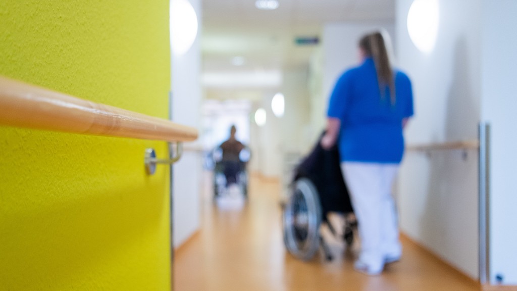 Eine Pflegerin schiebt einen Rollstuhl in einem Krankenhaus