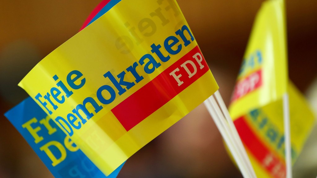 Fähnchen der FDP stehen in einem Glas auf einem Tisch.