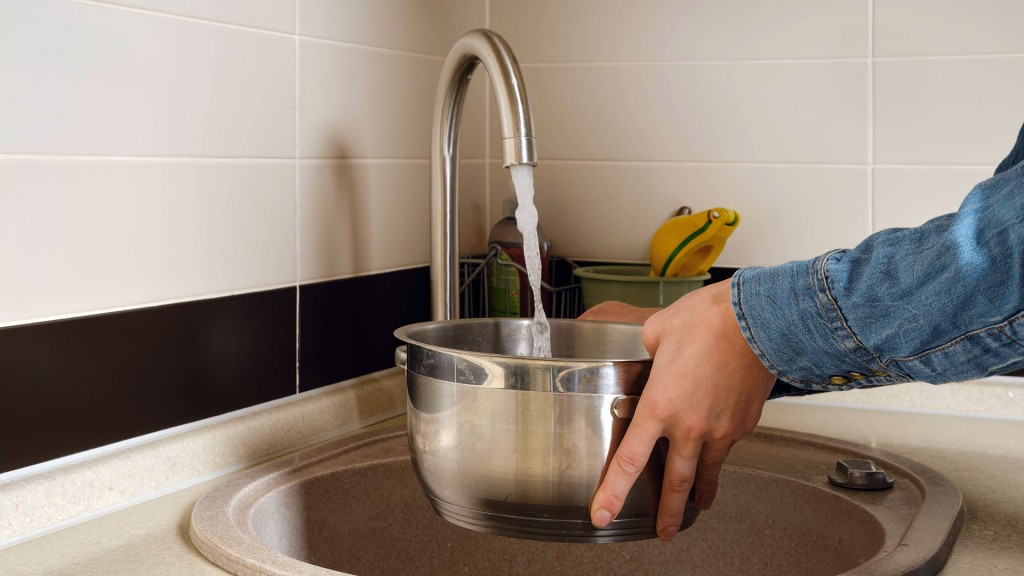 Foto: Eine Person lässt Wasser in einen Kochtopf laufen