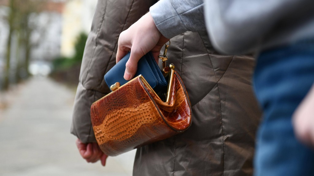 Ein Taschendieb greift sich die Geldböse aus der Handtasche einer älteren Frau.