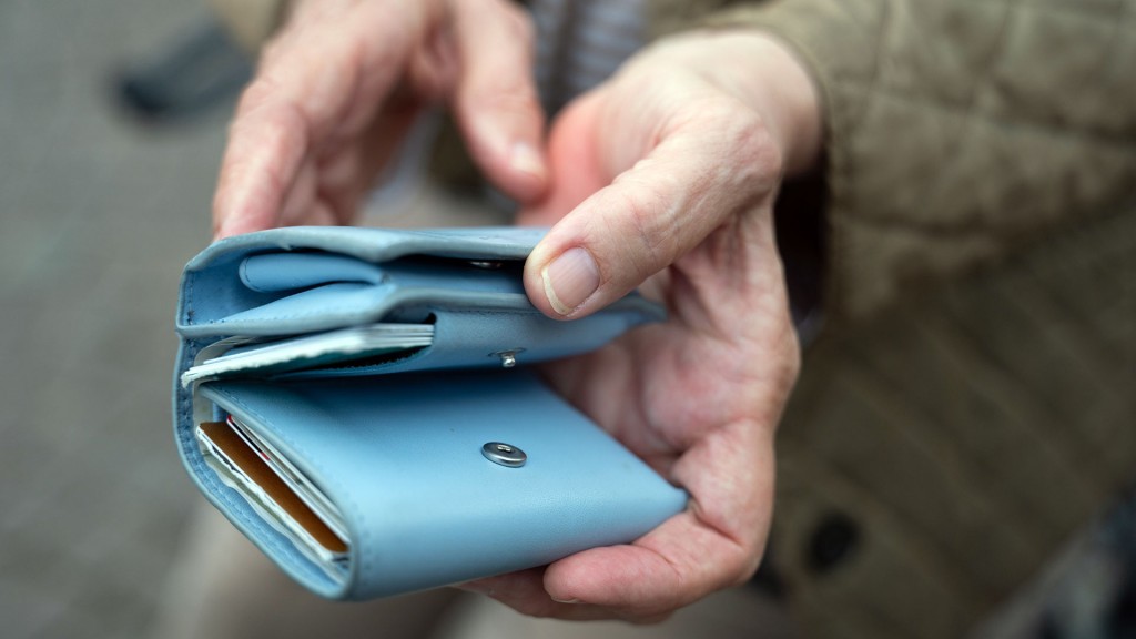 Eine Seniorin hält ein Portemonnaie in den Händen
