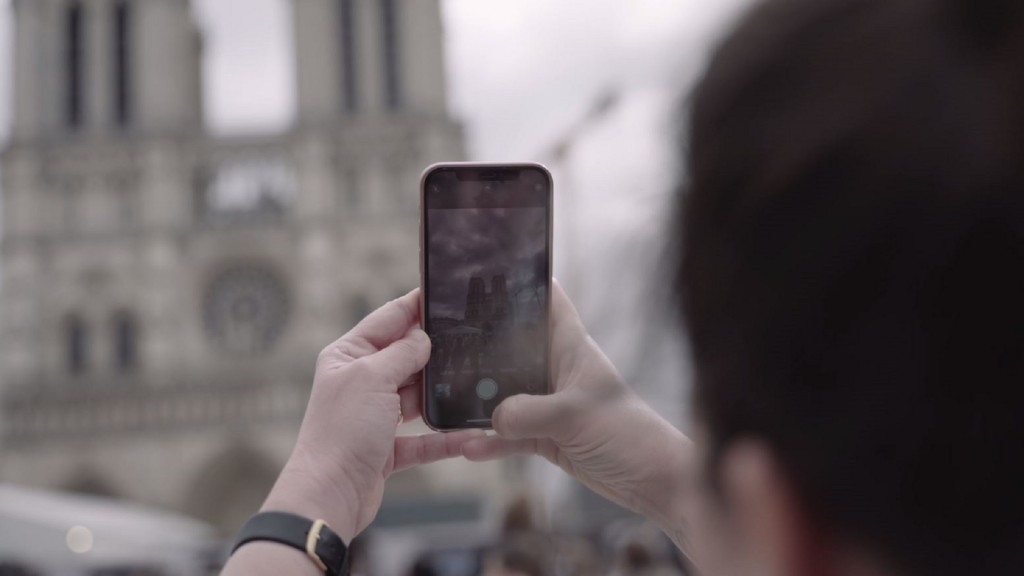 Jemand macht mit dem Smartphone ein Foto von Notre Dame de Paris
