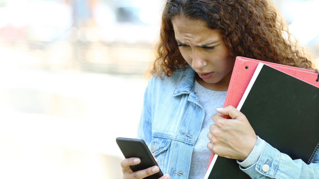 Junge Frau schaut mit Stirnrunzeln auf ihr Smartphone