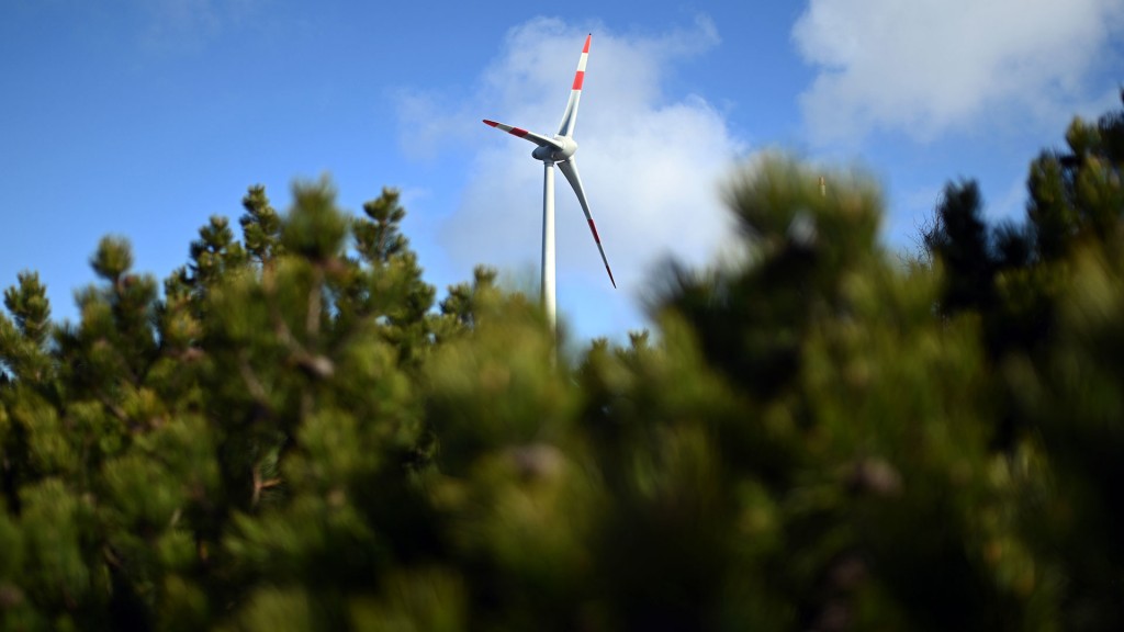 Eine Windenergie-Anlage steht nahe eines Waldes