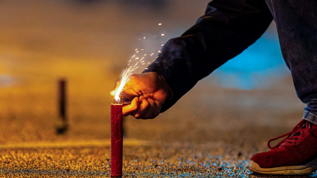 Jemand zündet einen Feuerwerkskörper an