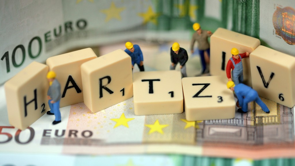 Spielzeugfiguren bauen am Schriftzug Hartz IV.