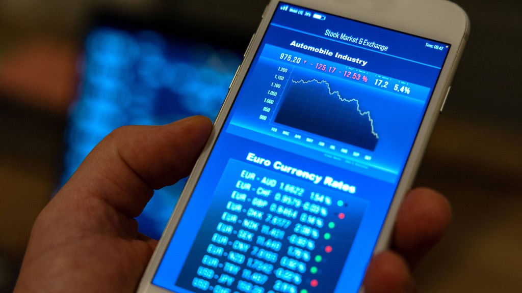 Jemand hält ein Smartphone mit Börsen-Charts in der Hand