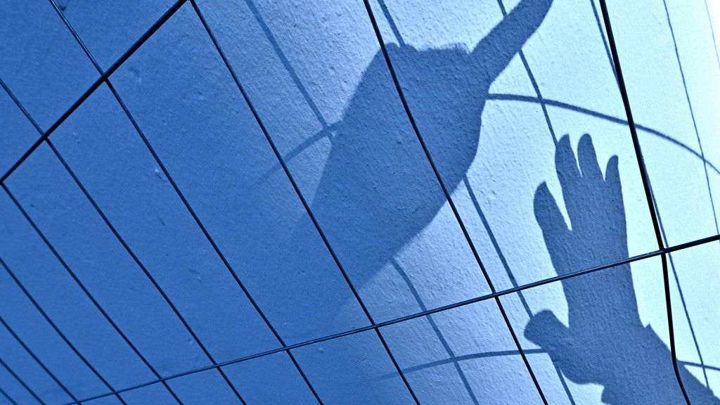 Schatten einer abwehrenden Hand und eines Messers an eine Wand