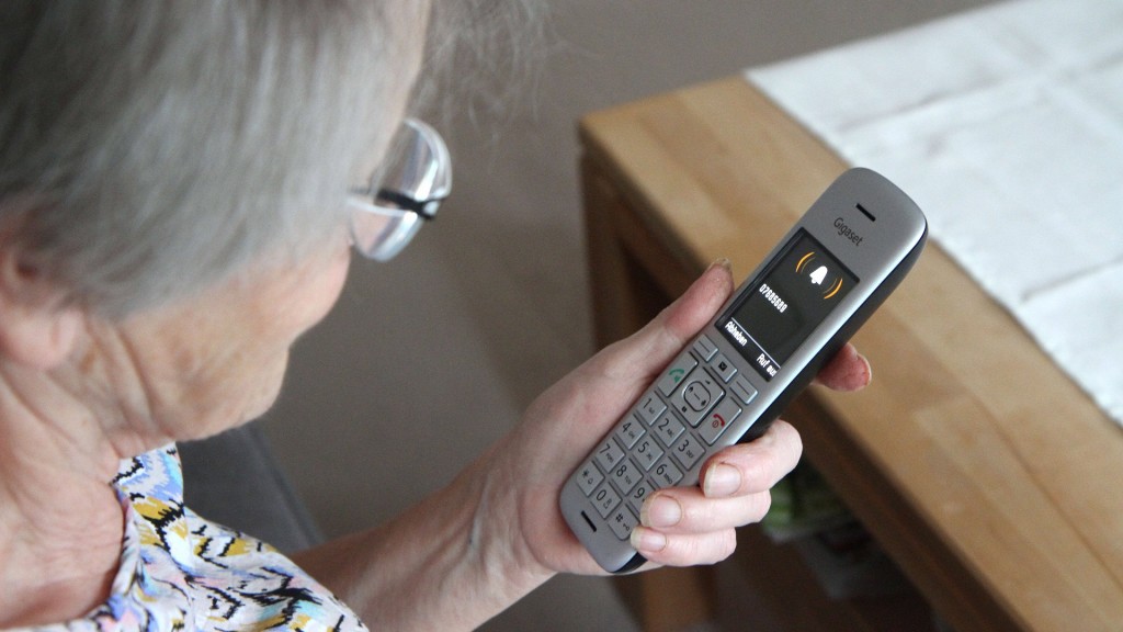 Eine ältere Frau hält das Telefon in der Hand