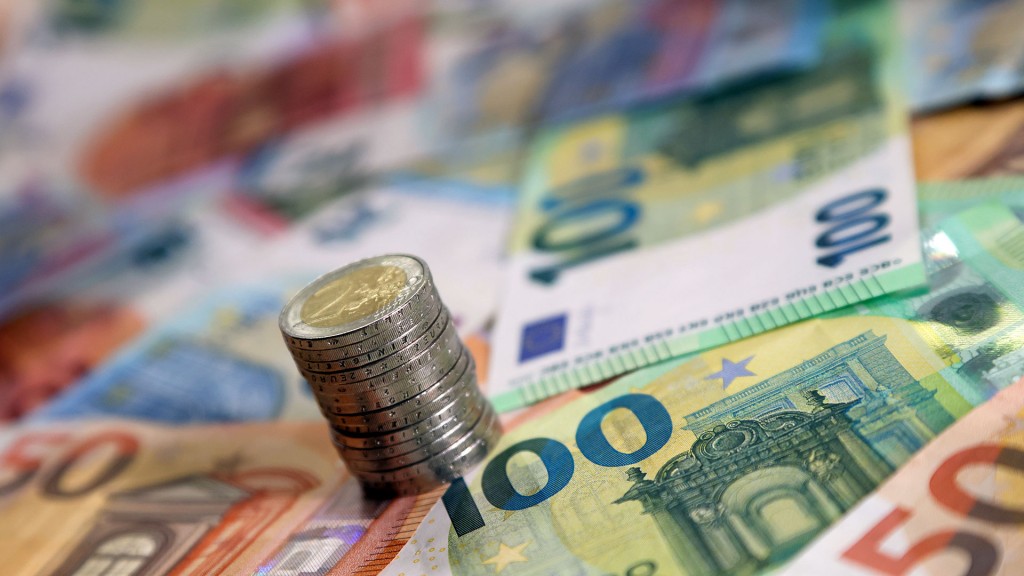 Ein Stapel mit Zwei-Euro-Münzen steht auf verschiedenen Euro-Banknoten