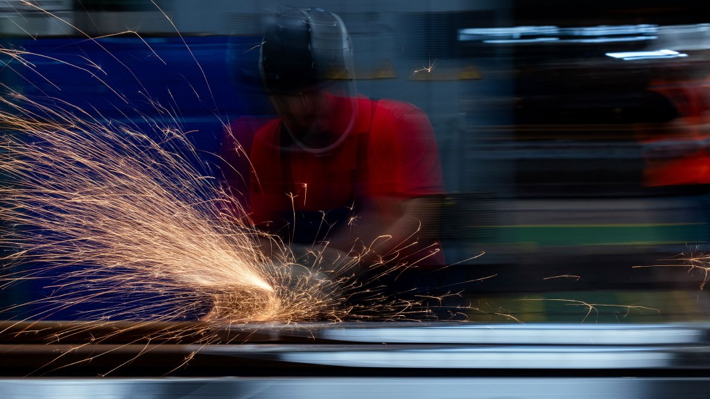 Ein Industrie-Arbeiter schleift ein Metallwerkstück