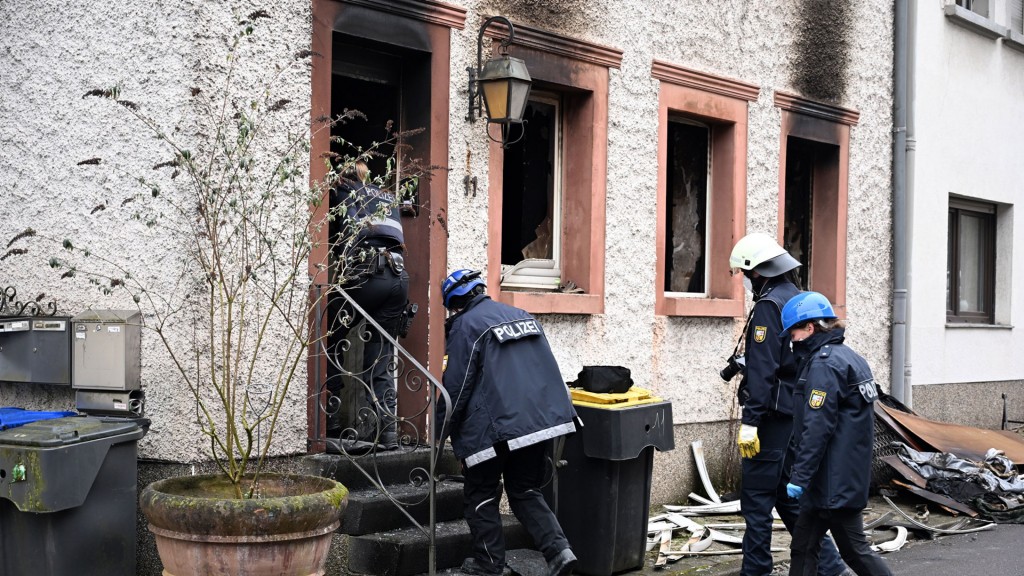 Brandermittler der Polizei betreten ein gelöschtes Wohnhaus in Dudweiler Jägersfreude