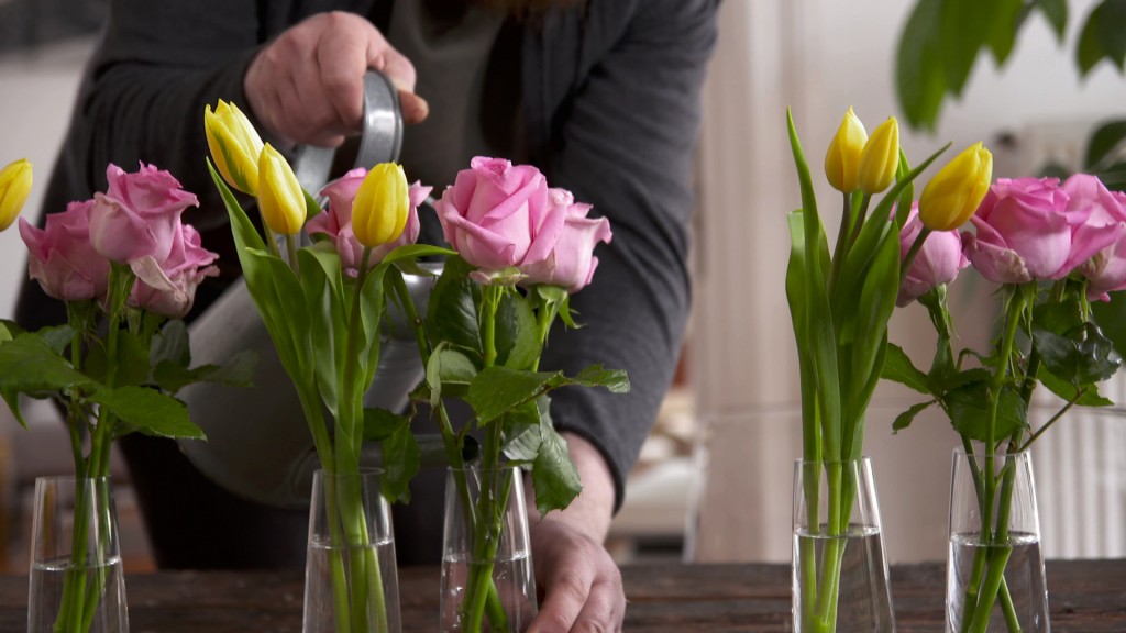 Ein Mann gießt Schnittblumen in einer Vase