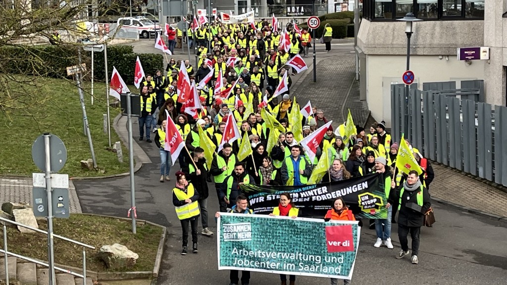 Streikende stehen mit Verdi-Fahnen in Saarbrücken