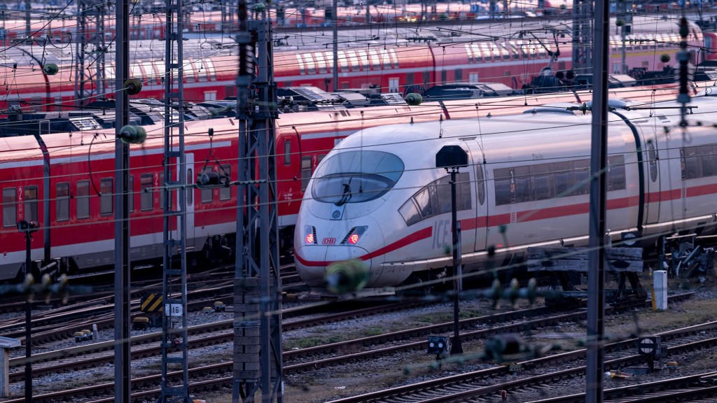 Foto: Ein ICE und rote Regionalzüge fahren in den frühen Morgenstunden am Münchner Hauptbahnhof ein. 
